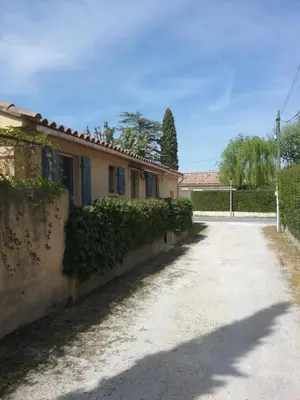 a road in front of a house with ivy at UNE CHAMBRE EN VILLE in LʼIsle-sur-la-Sorgue
