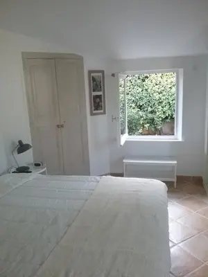 a white bedroom with a bed and a window at UNE CHAMBRE EN VILLE in LʼIsle-sur-la-Sorgue