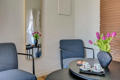 a room with two chairs and a table with cups and flowers at The View Aix-en-Provence in Aix-en-Provence