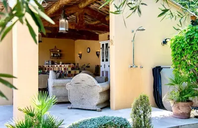 a patio with wicker chairs and plants at Évasion Provençale : Villa Élégante pour 10 Personnes in Villars
