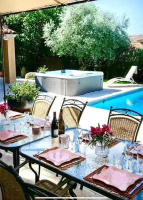 a table with glasses and wine bottles on a patio at Évasion Provençale : Villa Élégante pour 10 Personnes in Villars
