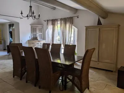 a dining room with a wooden table and chairs at Mas dans les lavandes in Ménerbes