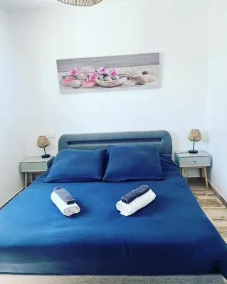 two phones on a blue bed in a bedroom at Les jardins de la Gravière à 5 mn de Lourmarin avec piscine privée in Puyvert