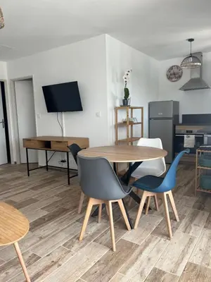 a living room with a wooden table and chairs at Les jardins de la Gravière à 5 mn de Lourmarin avec piscine privée in Puyvert