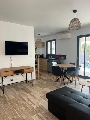 a living room with a couch and a table at Les jardins de la Gravière à 5 mn de Lourmarin avec piscine privée in Puyvert