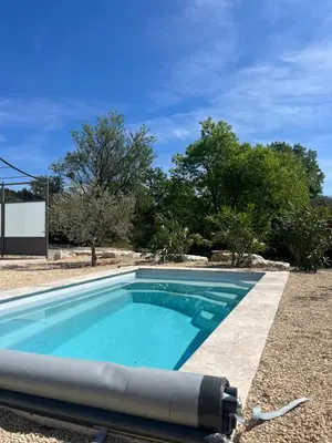 a swimming pool in the middle of a yard with trees at Les jardins de la Gravière à 5 mn de Lourmarin avec piscine privée in Puyvert