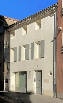 a white building with shuttered windows on a street at 