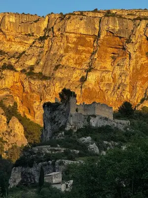an old building on a cliff with a mountain at 