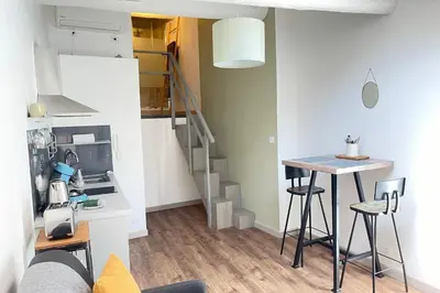 a small kitchen with a table and a staircase in a room at Under the Provençal Sun in LʼIsle-sur-la-Sorgue