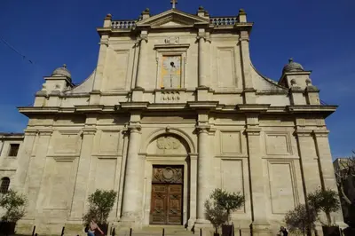 a large stone church with a large wooden door at Under the Provençal Sun in LʼIsle-sur-la-Sorgue