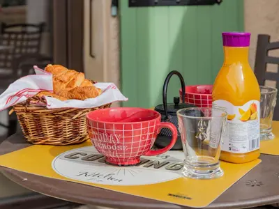a table with cups and a bottle of orange juice at Apartment L'Aquillon by Interhome in Noves