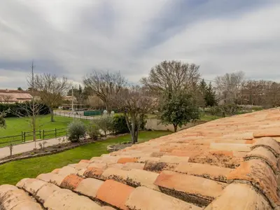 an old brick wall with a park in the background at Apartment L'Aquillon by Interhome in Noves