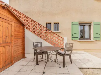a table and chairs on a patio with a staircase at Apartment L'Aquillon by Interhome in Noves