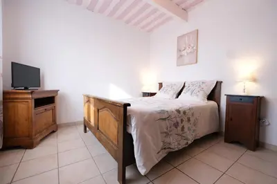 a bedroom with a bed and a tv on a table at pretty holiday rental with swimming pool in isle-sur-la-sorgue, in the département of vaucluse, in provence 4 people in LʼIsle-sur-la-Sorgue