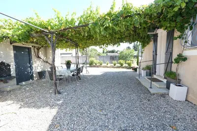 a patio with a table and a tree in a building at pretty holiday rental with swimming pool in isle-sur-la-sorgue, in the département of vaucluse, in provence 4 people in LʼIsle-sur-la-Sorgue