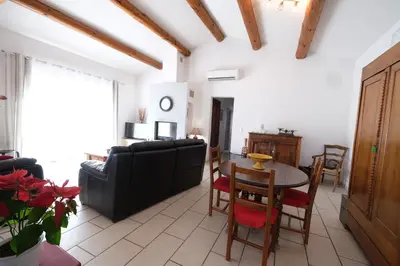 a living room with a black couch and a table at pretty holiday rental with swimming pool in isle-sur-la-sorgue, in the département of vaucluse, in provence 4 people in LʼIsle-sur-la-Sorgue