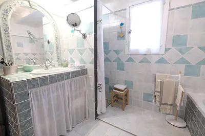 a bathroom with a sink and a tub and a mirror at pretty holiday rental with swimming pool in isle-sur-la-sorgue, in the département of vaucluse, in provence 4 people in LʼIsle-sur-la-Sorgue
