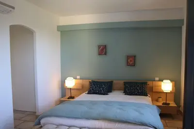 a bedroom with a large bed with two lamps at La Cath - Villa avec piscine - Gordes in Gordes