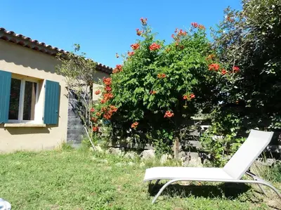 a white chair sitting in the grass in front of a house at Campagne de Saint Clair in Pertuis