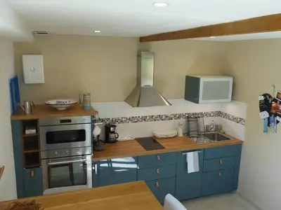 a kitchen with blue cabinets and a sink and a microwave at Campagne de Saint Clair in Pertuis