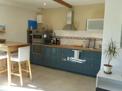 a kitchen with blue cabinets and a table and a stove at Campagne de Saint Clair in Pertuis