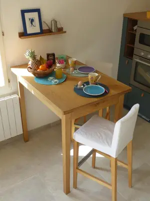 a wooden table with a bowl of fruit and a chair at Campagne de Saint Clair in Pertuis