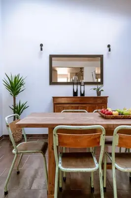 a dining room table with chairs and a mirror at Lou Roucas : Agréable maison de village avec vue in Fontaine-de-Vaucluse