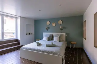 a bedroom with a large bed and a window at Lou Roucas : Agréable maison de village avec vue in Fontaine-de-Vaucluse