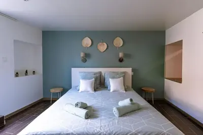 a bedroom with a large bed with two pillows on it at Lou Roucas : Agréable maison de village avec vue in Fontaine-de-Vaucluse