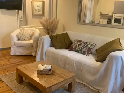 a living room with a white couch and a coffee table at Lou Magnan in LʼIsle-sur-la-Sorgue