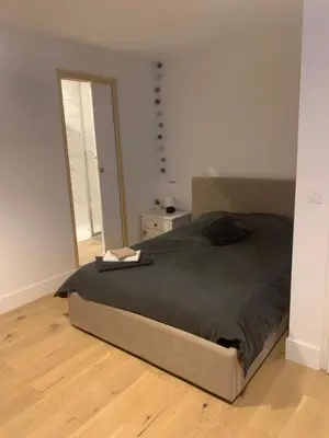 a bedroom with a bed and a wooden floor at Joli studio centre village in Lambesc