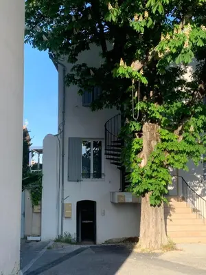 a white building with a tree in front of it at Joli studio centre village in Lambesc