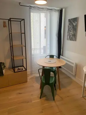a table and two chairs in a room with a window at Joli studio centre village in Lambesc