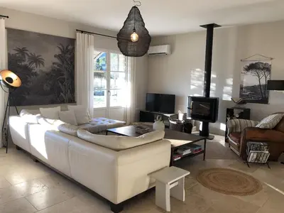a living room with a white couch and a tv at Bastide la Melonnerie in Lacoste