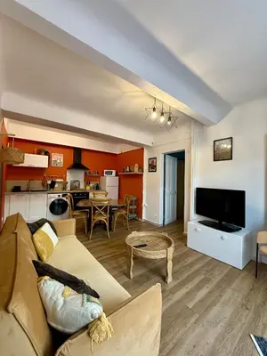 a living room with a couch and a kitchen at Sasha'blue-terrasse jardin-park-clim-piscine in LʼIsle-sur-la-Sorgue