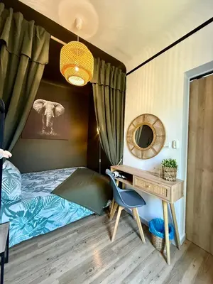 a bedroom with a bed and a desk with a chair at Sasha'blue-terrasse jardin-park-clim-piscine in LʼIsle-sur-la-Sorgue