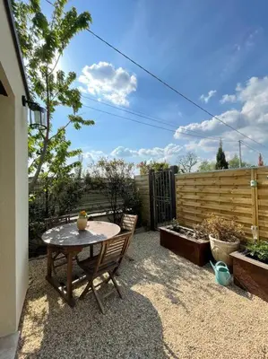 a patio with a table and chairs and a fence at Logement entier avec jacuzzi en provence in Le Thor