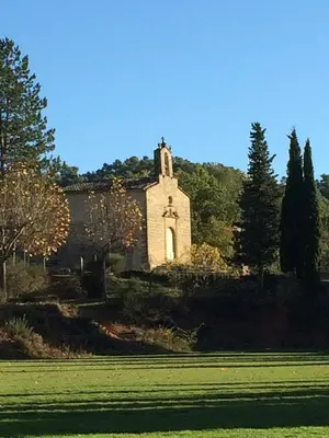 an old church sitting on top of a lush green field at La Reynière du Sud Luberon in La Bastide-des-Jourdans