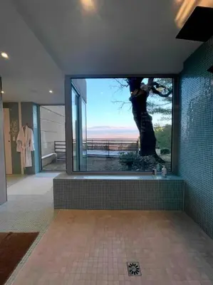 a bathroom with a large window with a tree in it at La Beaume in Blauvac