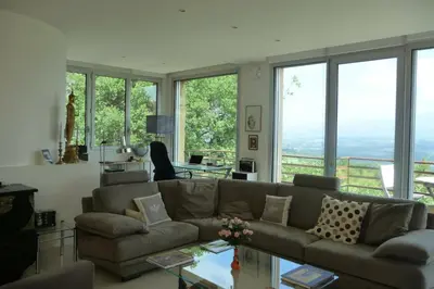 a living room with a couch and large windows at La Beaume in Blauvac