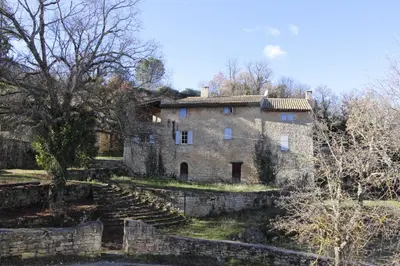 an old stone house with stairs leading up to it at Les Grottes in Sivergues