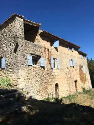a large brick building with white windows on it at Les Grottes in Sivergues