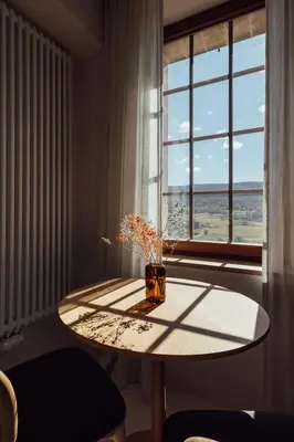 a table with a vase on it in front of a window at Le Pavadou B&B in Méthamis