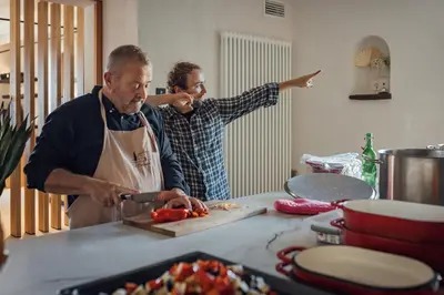 two people standing in a kitchen preparing food at Le Pavadou B&B in Méthamis