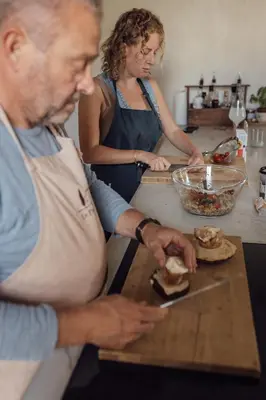 a man and a woman making a sandwich in a kitchen at Le Pavadou B&B in Méthamis