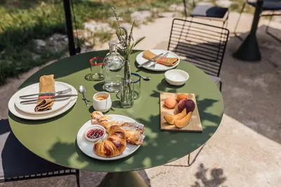 a green table with plates of food on it at Le Pavadou B&B in Méthamis