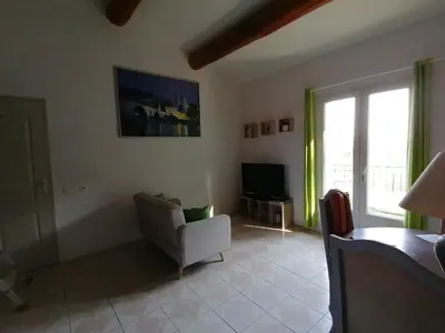 a living room with a chair and a television at Le Tavan in Crillon-le-Brave