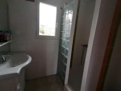 a bathroom with a sink and a shower with a window at Le Tavan in Crillon-le-Brave