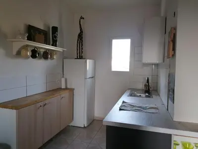a kitchen with a white refrigerator and a sink at Le Tavan in Crillon-le-Brave