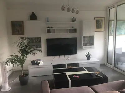 a living room with a flat screen tv on a wall at Les Cerisiers. in Aix-en-Provence